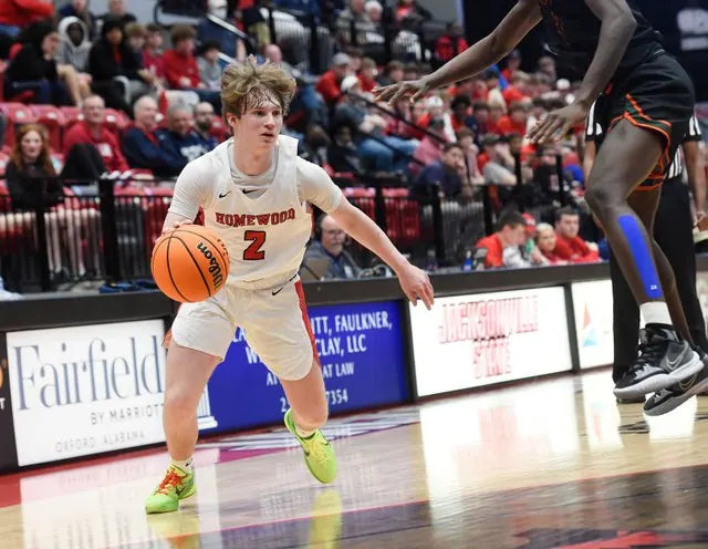 Carter Vail in the white Homewood number 2 jersey dribbling upcourt