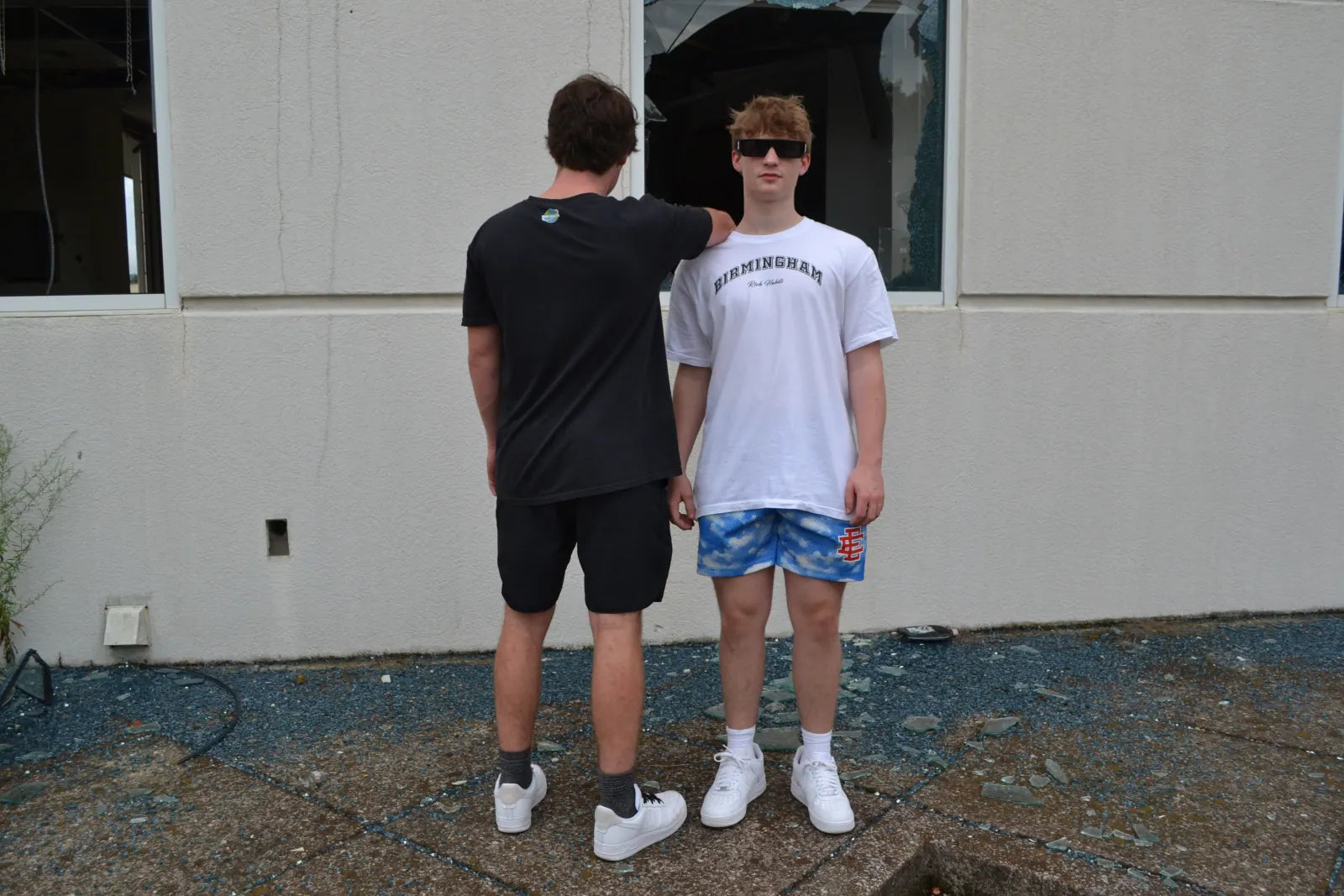 Sam Carr pointing at the shirt on Carter Vail's chest against a white wall