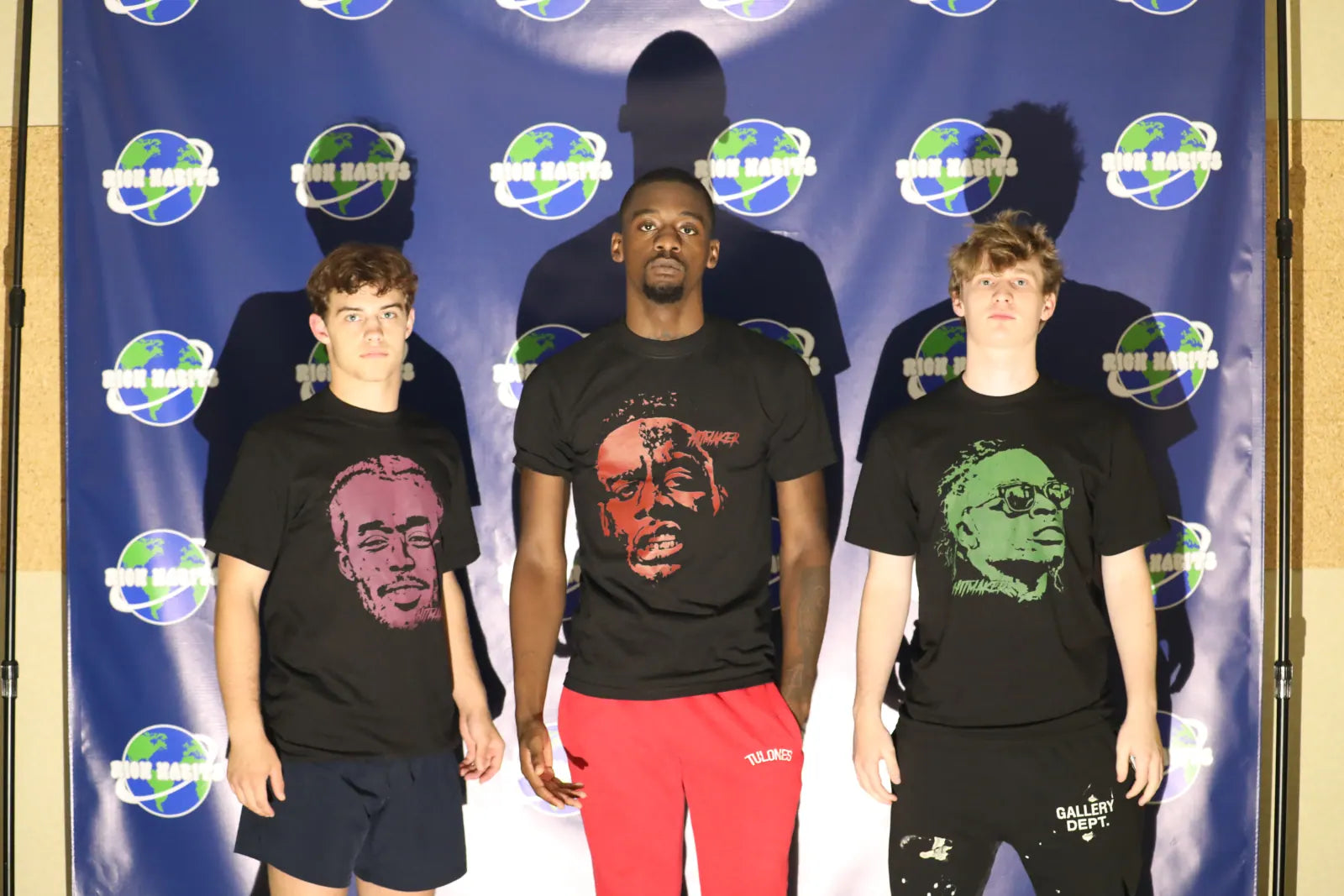 Sam Sutton, Luh Soldier and Carter Vail in three Hitmaker portrait tees in front of the globe backdrop