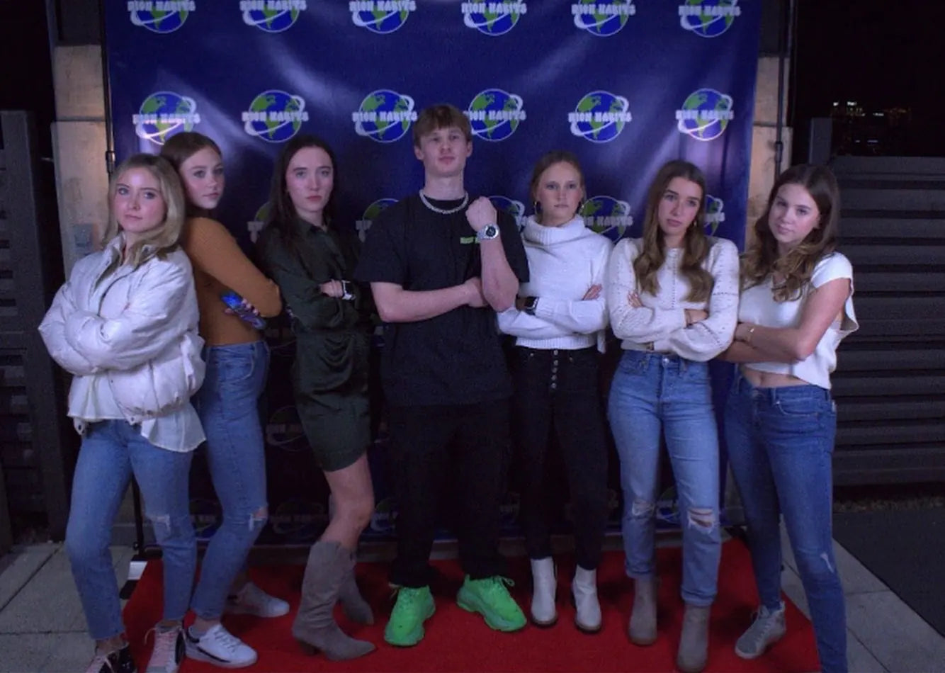 Carter Vail with seven friends, arms crossed, on the red carpet