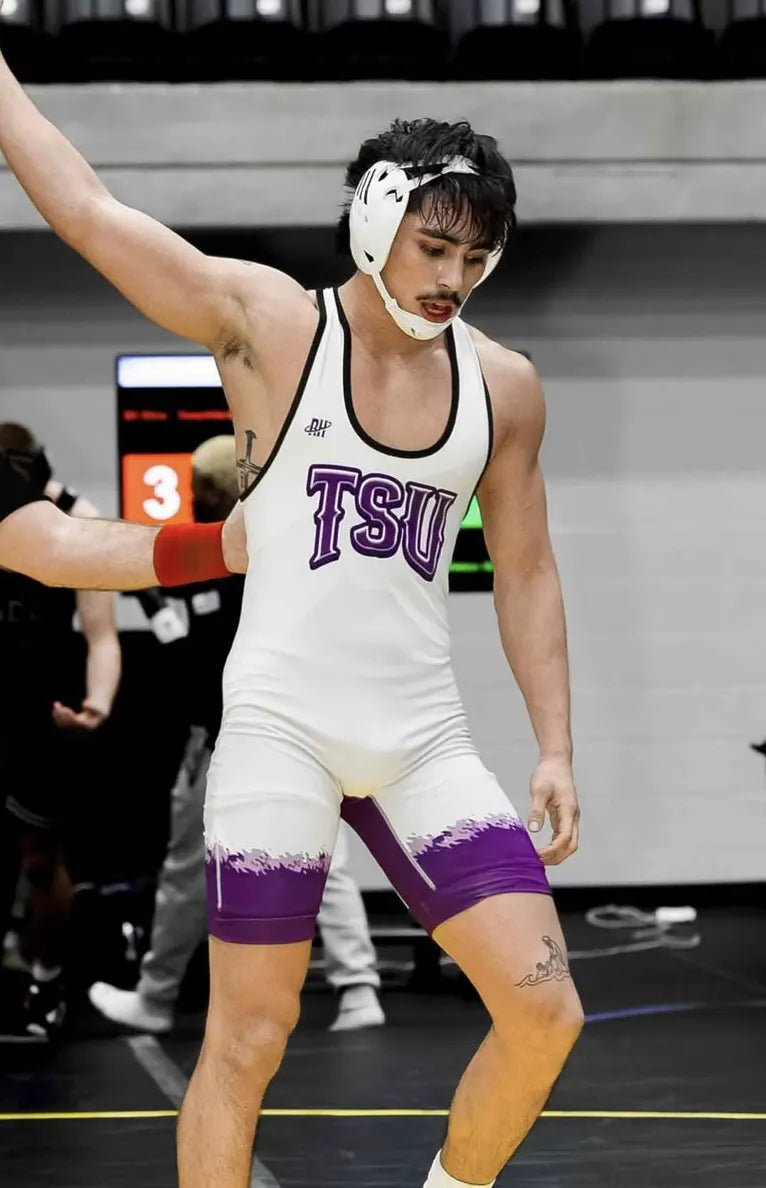Nico Egbalic with his arm raised in the white and purple Tarleton singlet made by Rich Habits