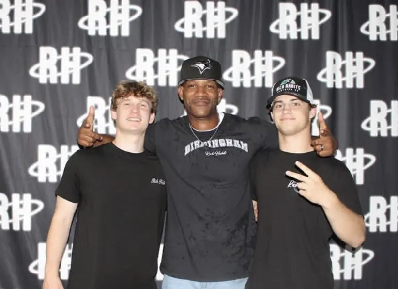 Sam Sutton, Coach Sills and Carter Vail in front of the RH monogram backdrop