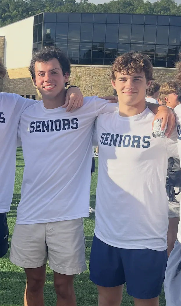 Sam Sutton and Charlie Reeves in matching Seniors tees with their arms around each other