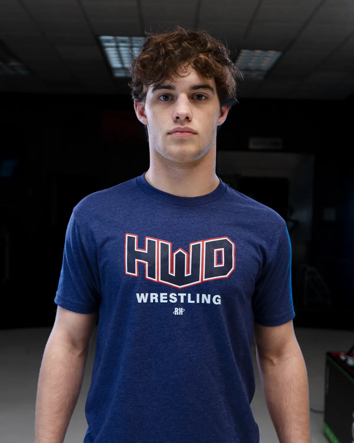 Sam Sutton in a navy Homewood Wrestling tee, studio portrait