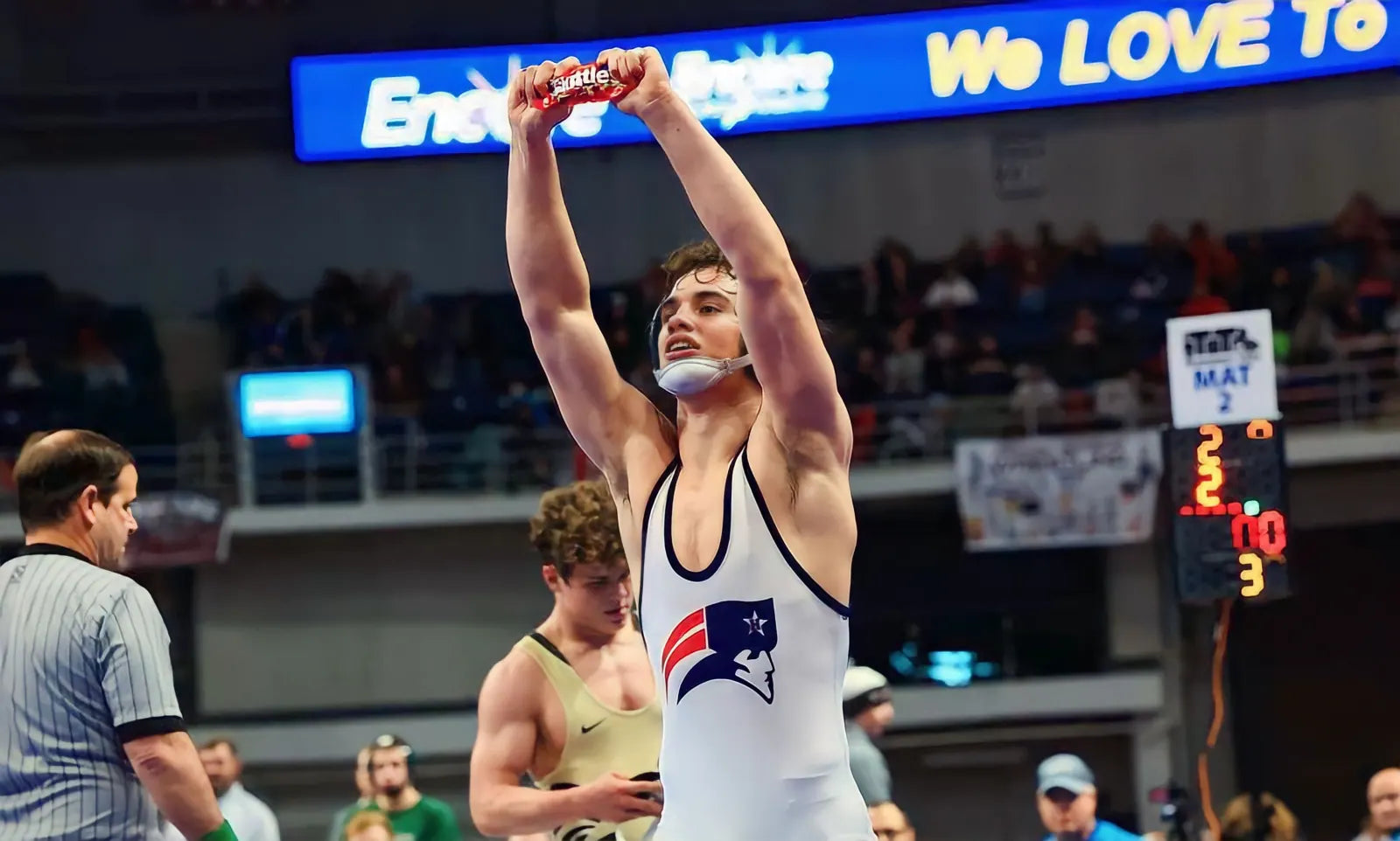 Sam Sutton with his arms raised after winning the state final, a bag of Skittles in his hand