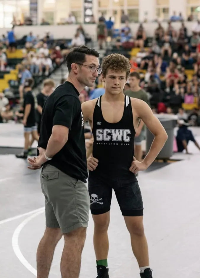 A Skull and Crossbones Wrestling Club wrestler in the SCWC singlet with his coach