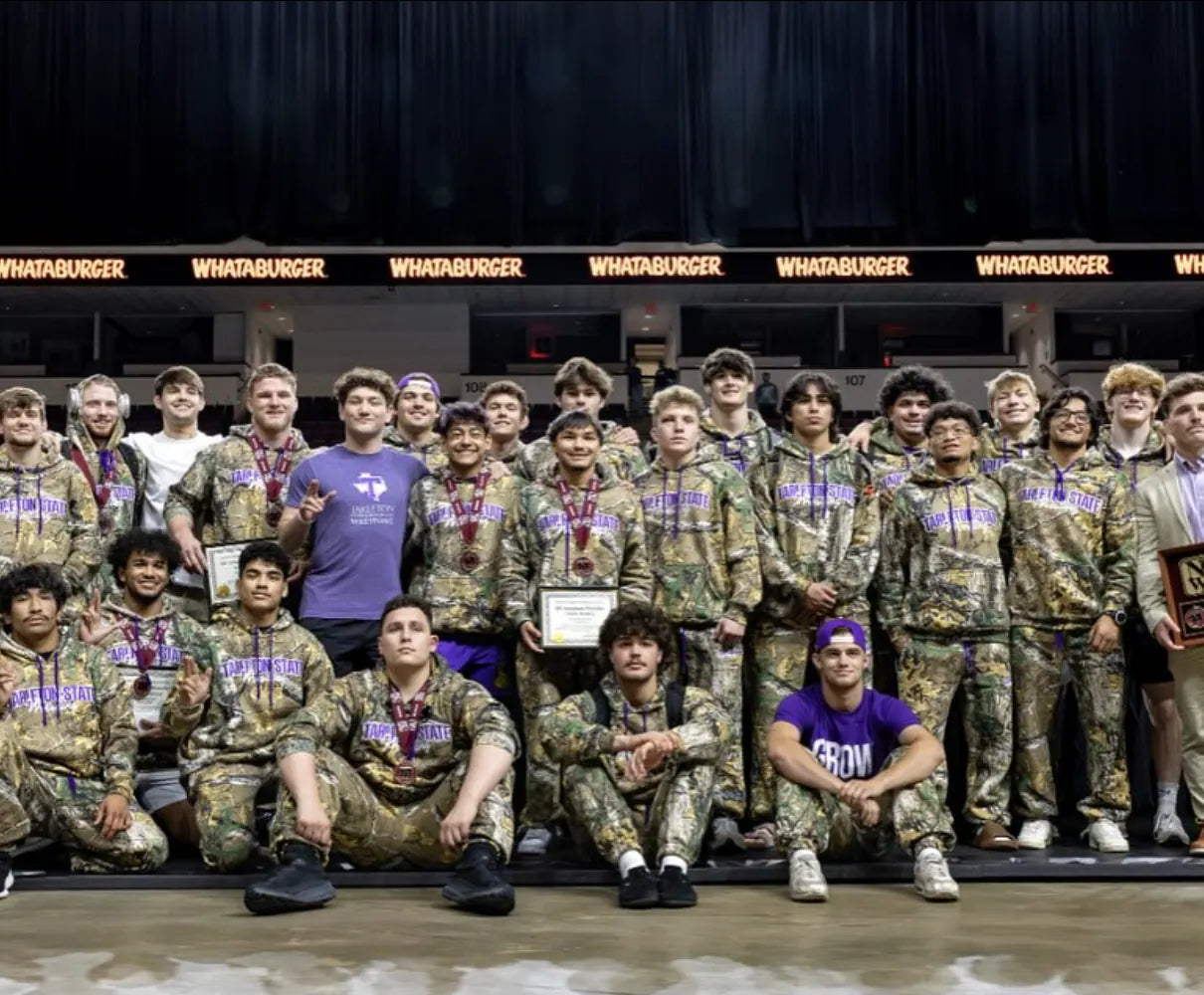 The Tarleton State team on the arena floor in camo Rich Habits hoodies, wearing medals