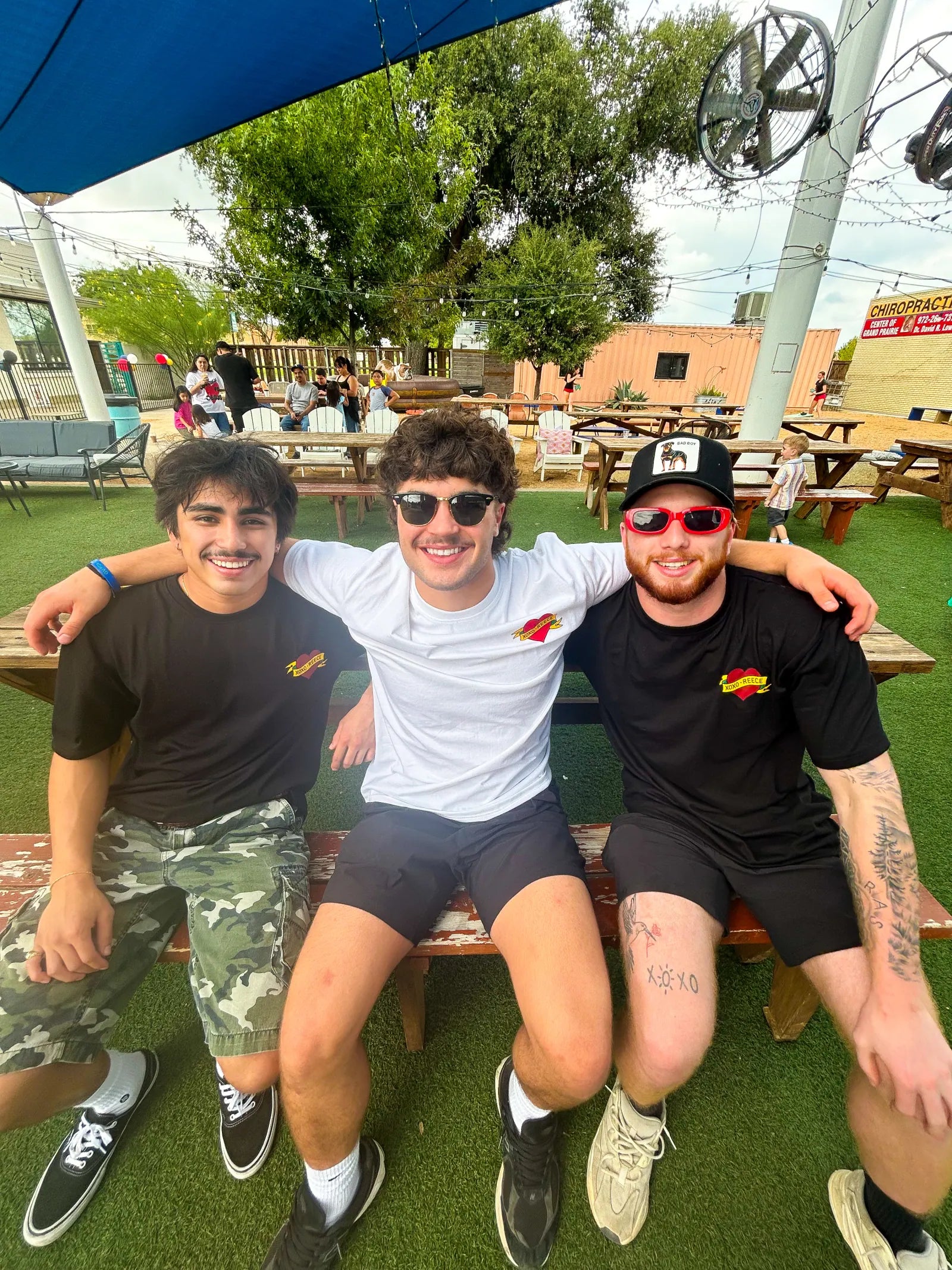 Nico Egbalic, Gavin and Finn on a bench in XOXO Reece tees