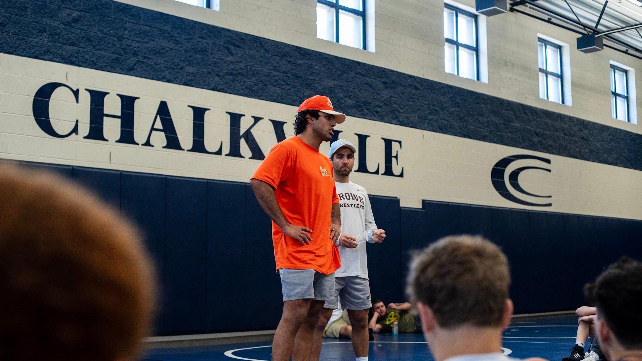Coaches speaking in front of Chalkville wall