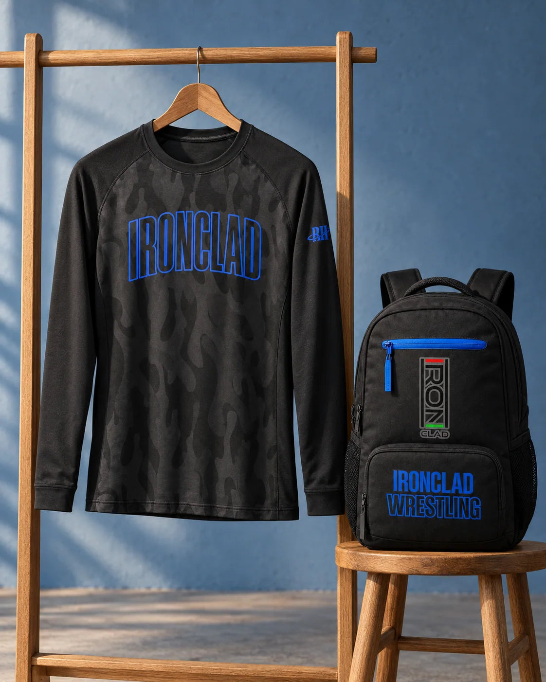 Black Ironclad shirt and matching backpack on a wooden rack and stool